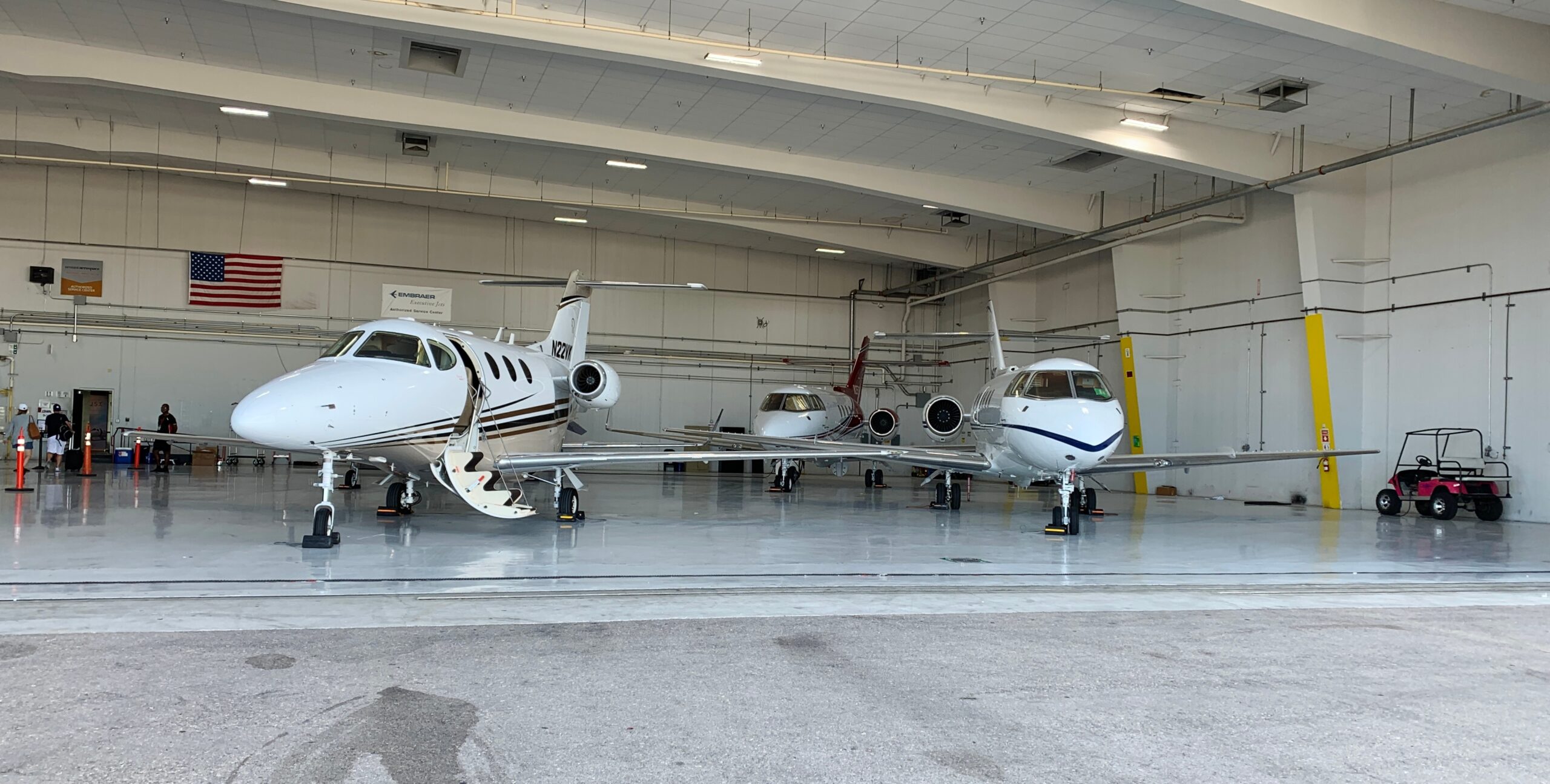 three private jets in an airport hanger