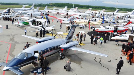 People looking at private jets on the tarmac at EBACE