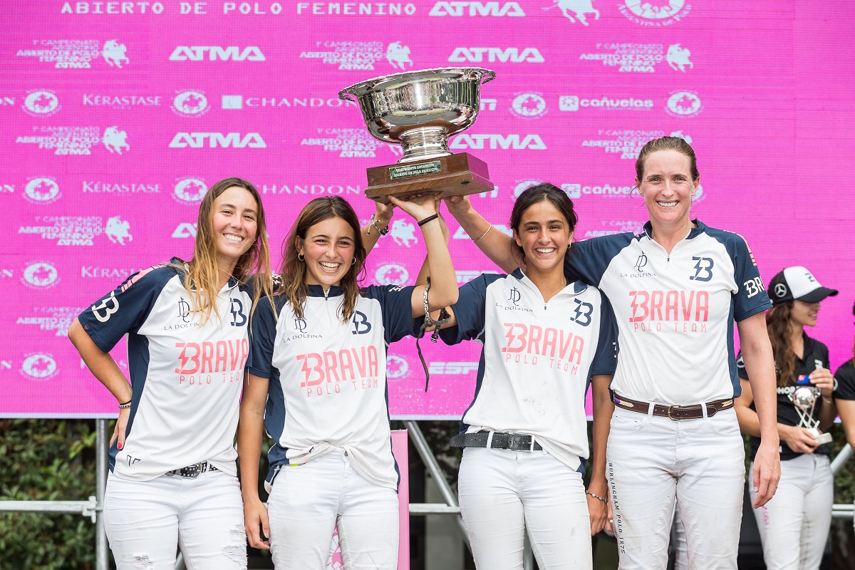 Four female polo players hoisting the trophy of the Argentine Open Women's Polo Championship.