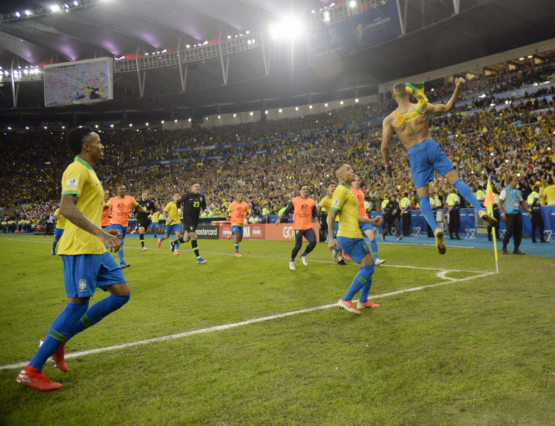 Brazilian soccer players celebrating in front of fans after a goal at the CONMEBOL Copa América.