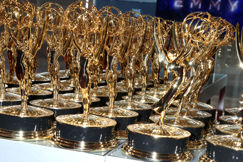Several rows of Emmy Awards golden statuettes.