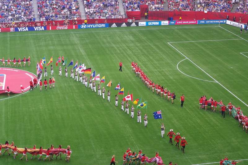 Little girls parading country flags on the field prior to a FIFA Women's World Cup match.