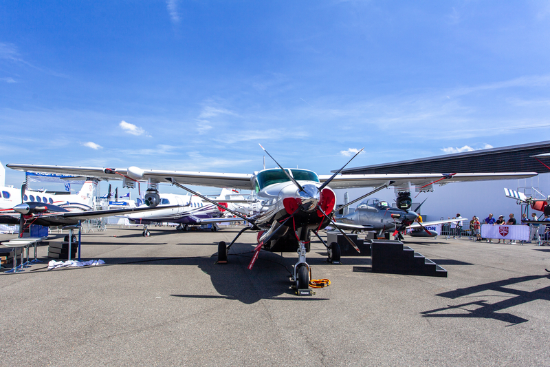 Multiple small airplanes parked on the tarmac at the France Air Expo.