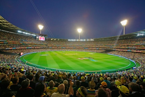 Fans filling a lit-up stadium and watching a night game at the ICC Men's Cricket World Cup