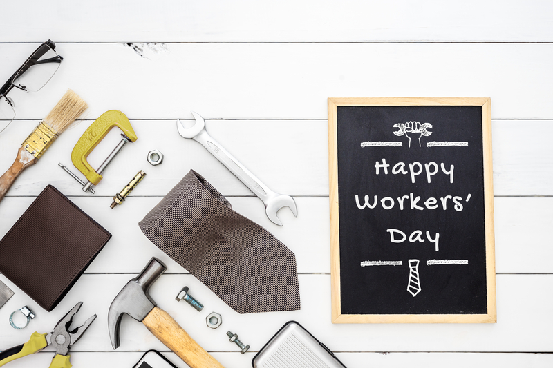 Happy International Workers' Day on a chalkboard to the right of several tools.