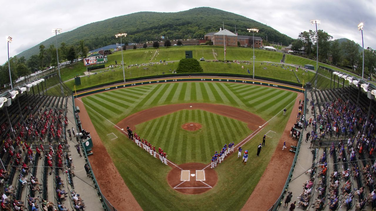 Stadium and field view with the baseball teams lined up on the foul lines before the Little League World Series.