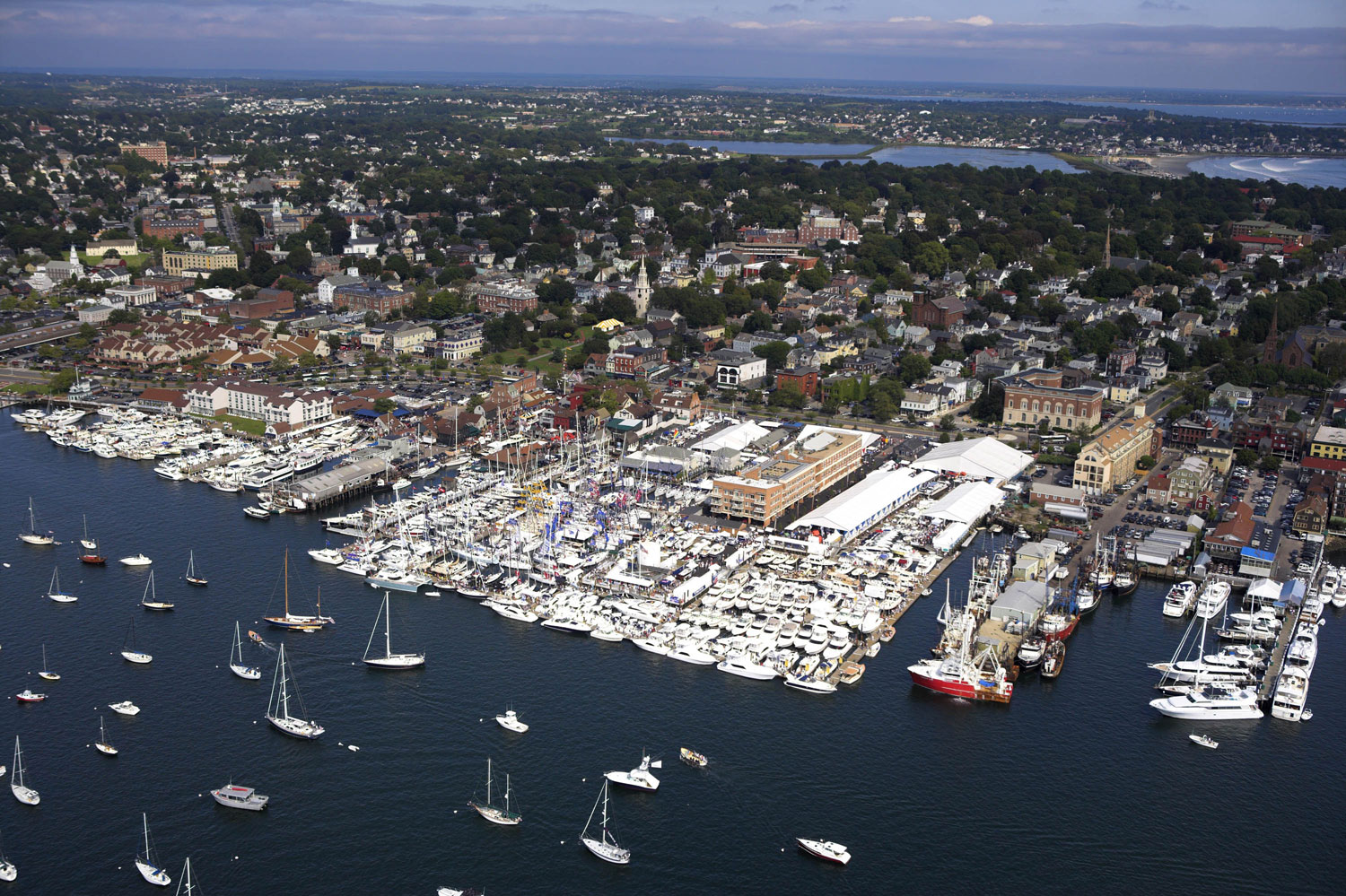 Yachts and superyachts sailing, anchored, and docked at the Newport Charter Yacht Show.