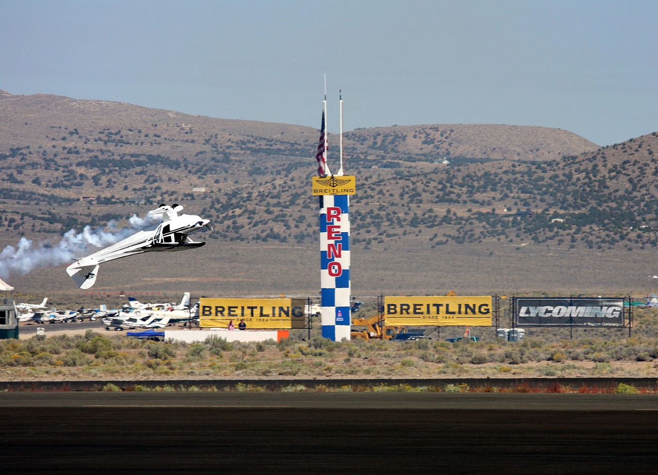 Airplane flying inverted near a pylon at the Reno Air Races.