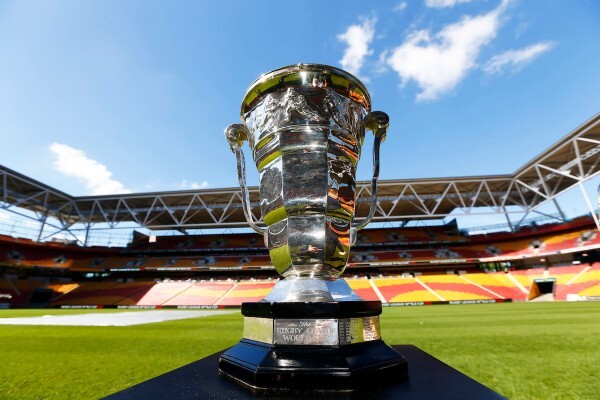Rugby League World Cup trophy in the foreground with a stadium interior in the background.