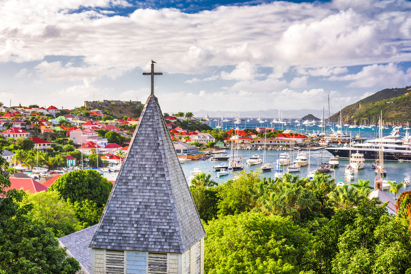 Picturesque harbor view with church steeple in foreground during St Barths Bucket Regatta.