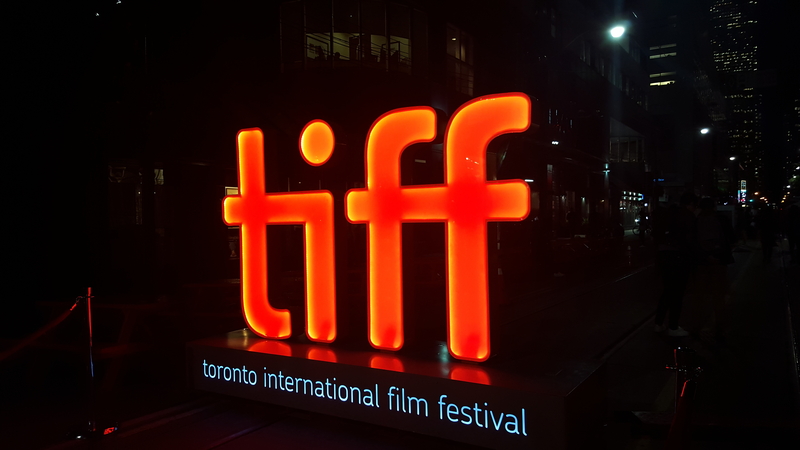 Red slights spelling out tiff above white lights spelling out Toronto International Film Festival.