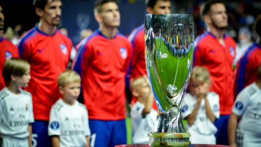 UEFA Super Cup trophy in front of players and kids lined up during the introductions.