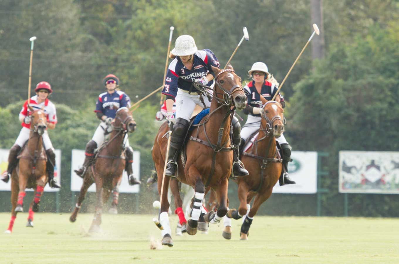 Four polo players and their horses competing at the US Open Women's Polo Championship.
