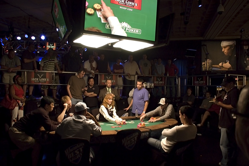 Poker players at a table with spectators watching at the WSOPE Main Event.