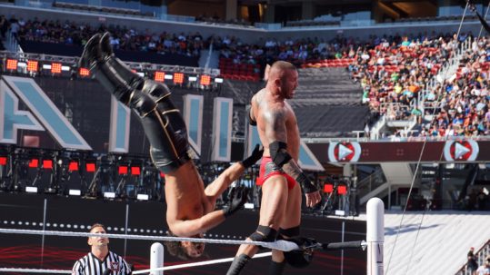 One wrestler flipping another at WrestleMania.