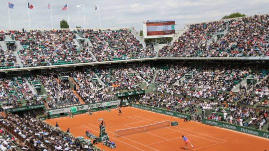Tennis players competing on clay courts at the French Open (Roland-Garros).