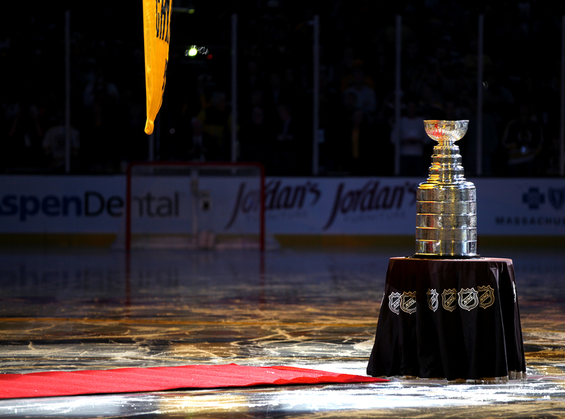 Stanley Cup trophy on a pedestal on the ice of a hockey rink at the Stanley Cup Finals.