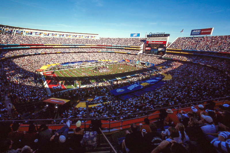 Football stadium with a sellout crowd watching the Super Bowl on a sunny day.