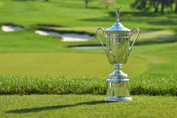 Trophy of the US Open Championship (Golf) trophy sitting on the ground of a tee box overlooking the fairway