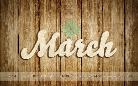 Green shamrock above the word March written in tan cursive on a wood panel background for March Events.