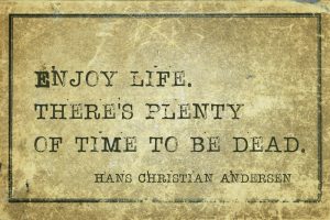 Famous Danish fairy tale writer Hans Christian Andersen quote printed on grunge vintage cardboard: 'Enjoy life. There's plenty of time to be dead.'