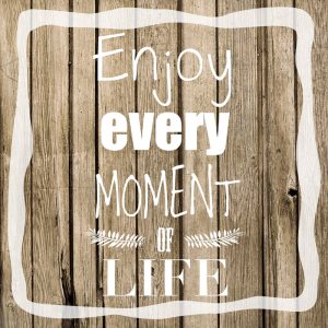 Best motivational quotes about enjoying life quote over wooden table saying 'Enjoy every moment of life'