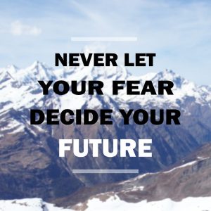 Motivational quote: 'Never let your fear decide' on blurred snow-peaked mountain background